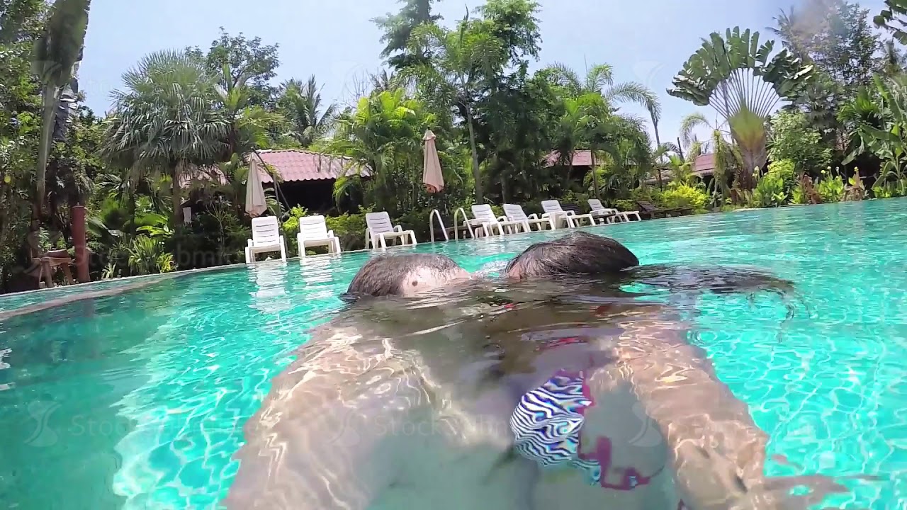 Young pretty couple in love swims dives underwater in the pool and has kissing. 1920x1080