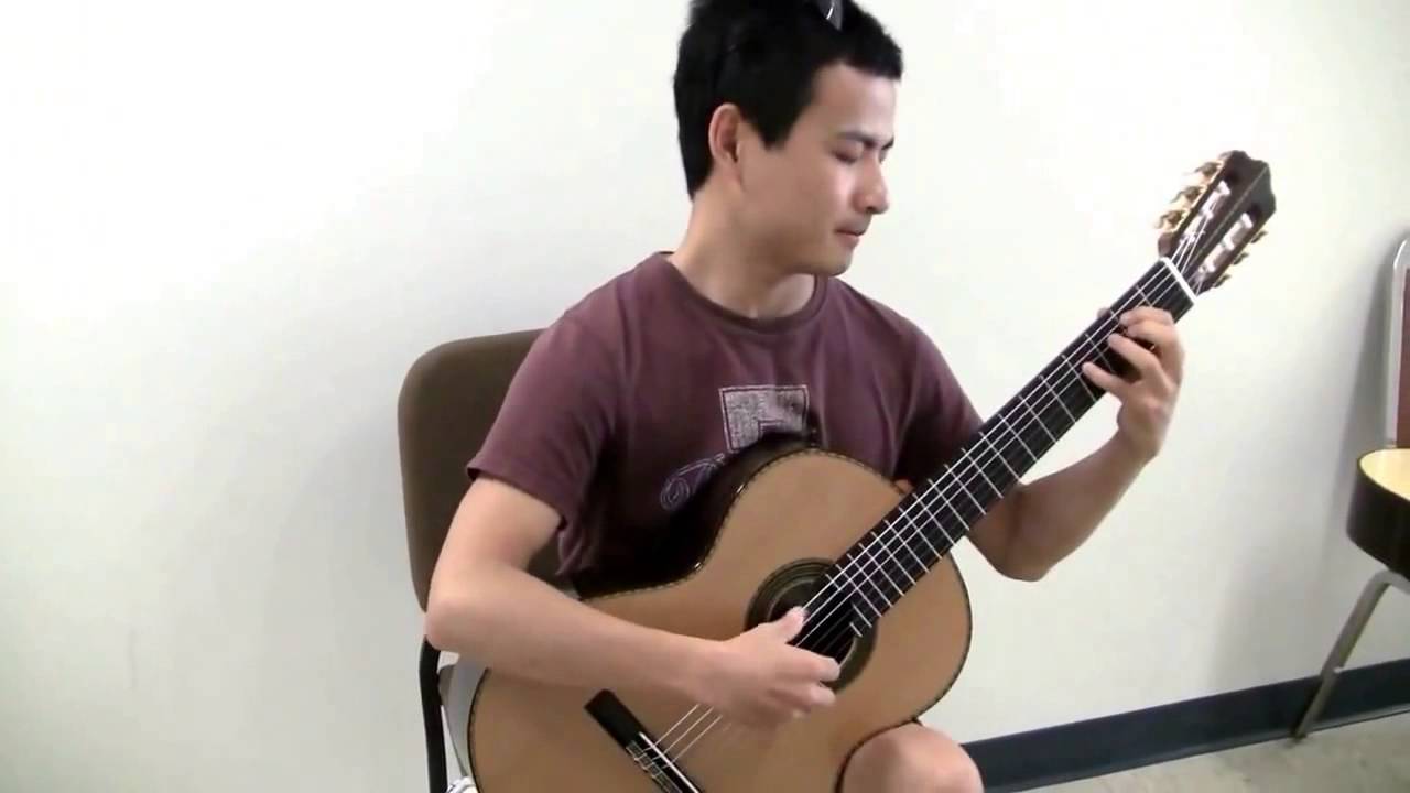 Bin Hu trying a guitar make by Erez Perelman