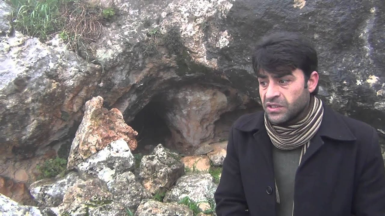 شاهدٌ أمام غارٍ اختبأ فيه لينجو من مجزرة وادي بدمايا.avi