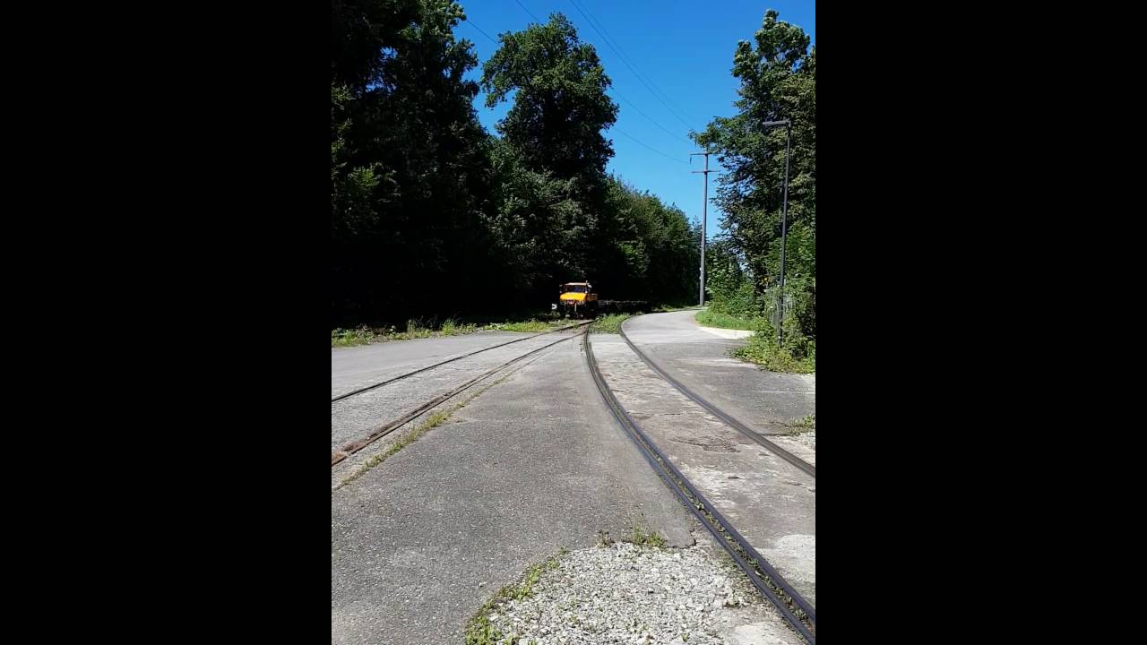 Dienstfahrzeug Unimog 421 rangiert unbeladenen Containertragwagen