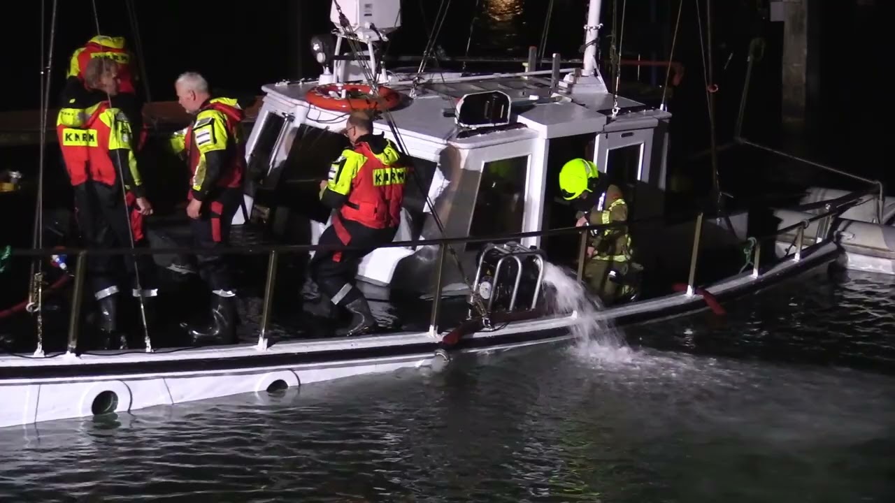 Hulpdiensten redden zinkend schip in de haven van Oudeschild