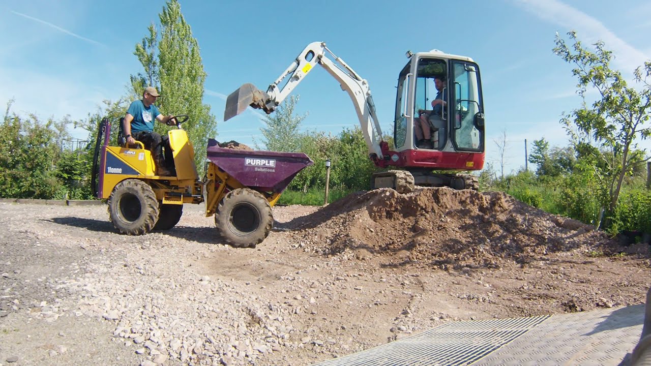 Mini Digger and Dumper moving a big pile of stone Takeuchi TB216 Excavator