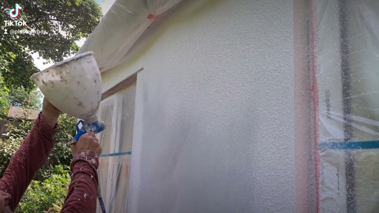 Spraying Jub thin coat silicone render.