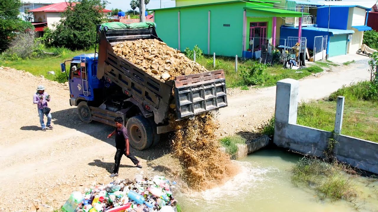 The land flood delete use bulldozer and dump truck push the stone for remove the water