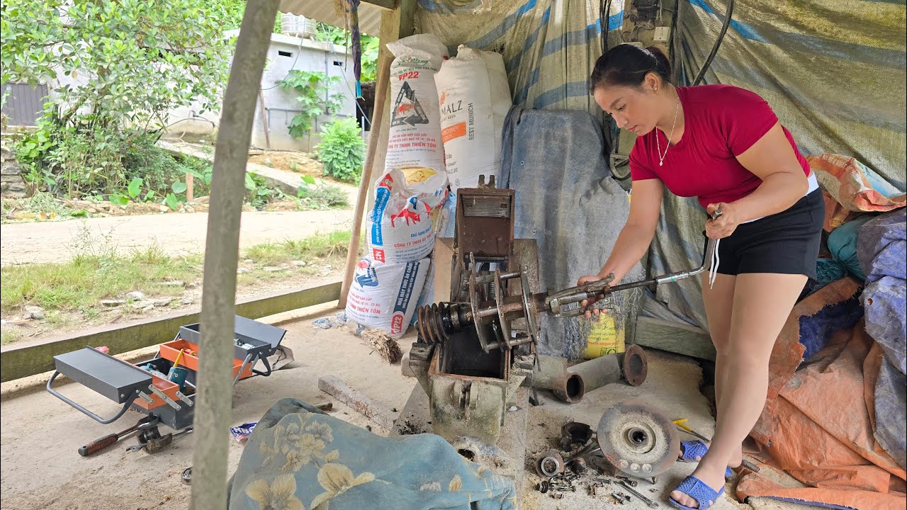 The girl repaired the rice separating machine for the people, the process of repairing the machine.