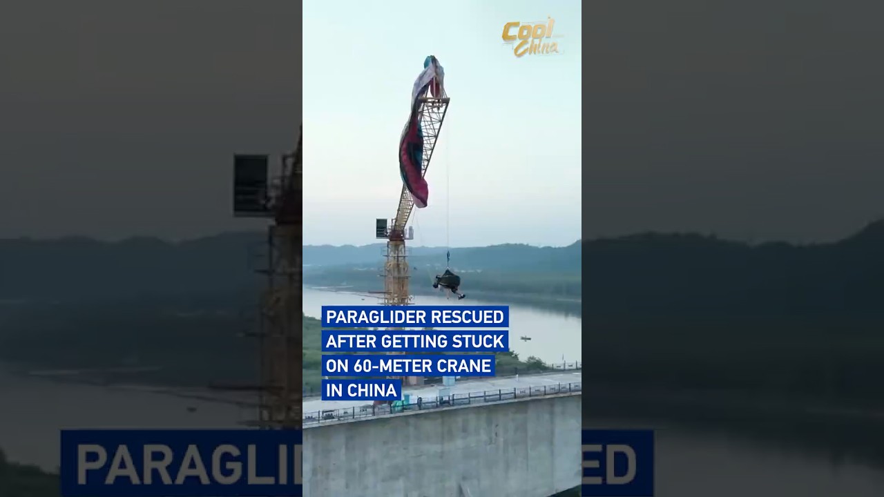 Paraglider rescued after getting stuck on 60-meter crane in China #coolchina