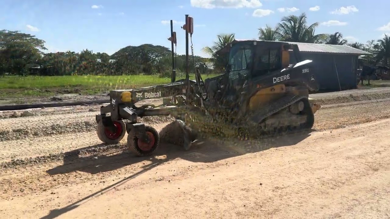 Deere 331g with bobcat grader blade attachment and Trimble laser guided automatics. 