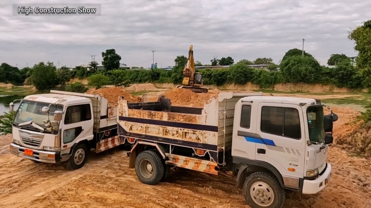 Heavy Machinery Coordination: Big Excavator Loading Dump Truck For Construction
