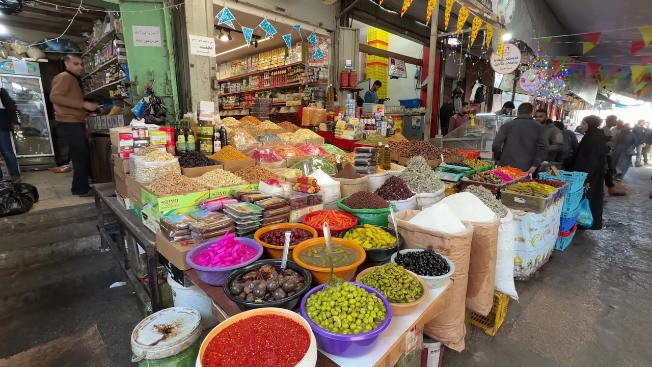 مواطنون يتجولون في سوق الزاوية بمدينة غزة خلال شهر رمضان بعد أن تضرر السوق بشدة  خلال الحرب