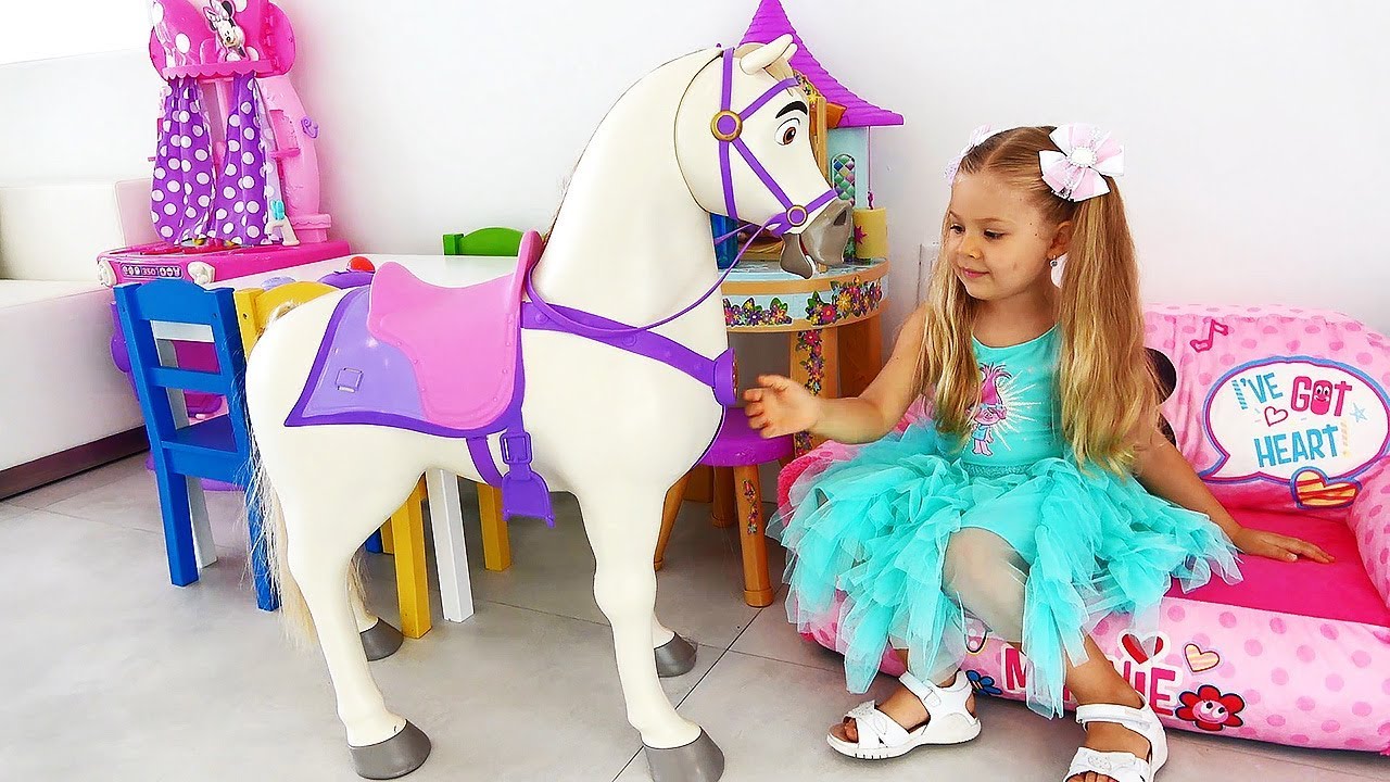 Диана играет с куклой принцессой Рапунцель и её лошадкой