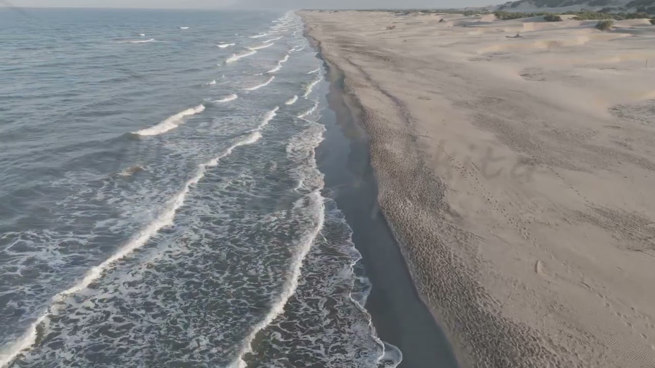 D-Log M. Gelemis, Turkey. Low angle shot over Mediterranean waves on Patara Beach, foam on sand w...