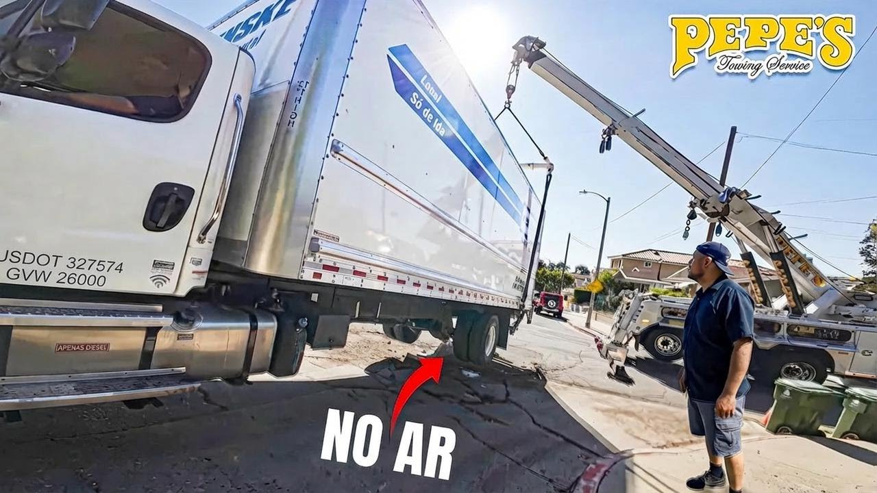 Caminhão baú da Penske fica preso em entrada de casa