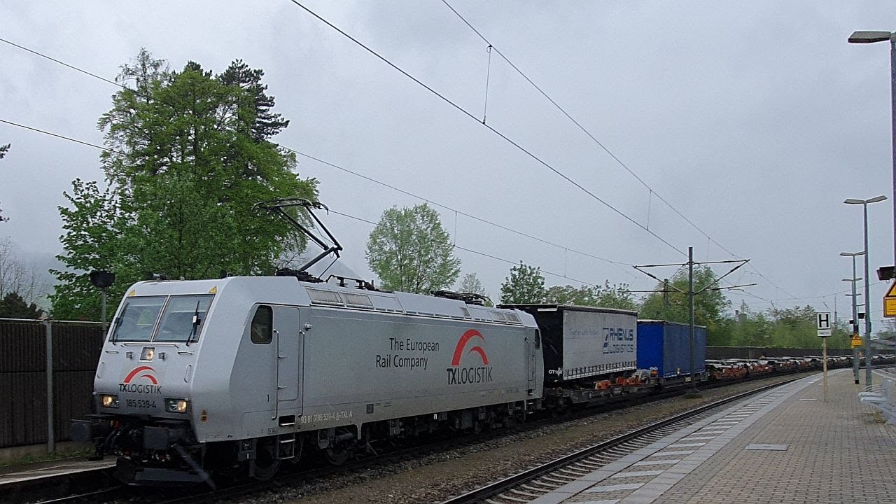 Zugverkehr in Brannenburg (Oberbayern): Mit einer Rola und einer Baureihe 119 im Dauerregen