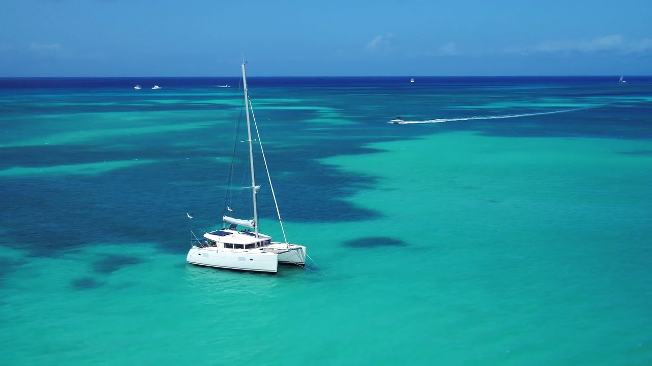 sail boat in beautiful blue ocean water aerial drone