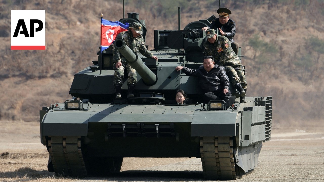 North Korean leader sits on tank with his daughter at military exercise