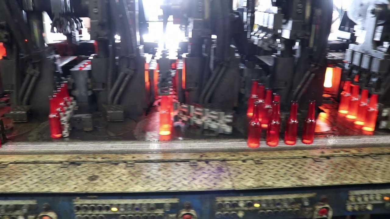 Glass bottles coming out the moulds glowing hot - Encirc
