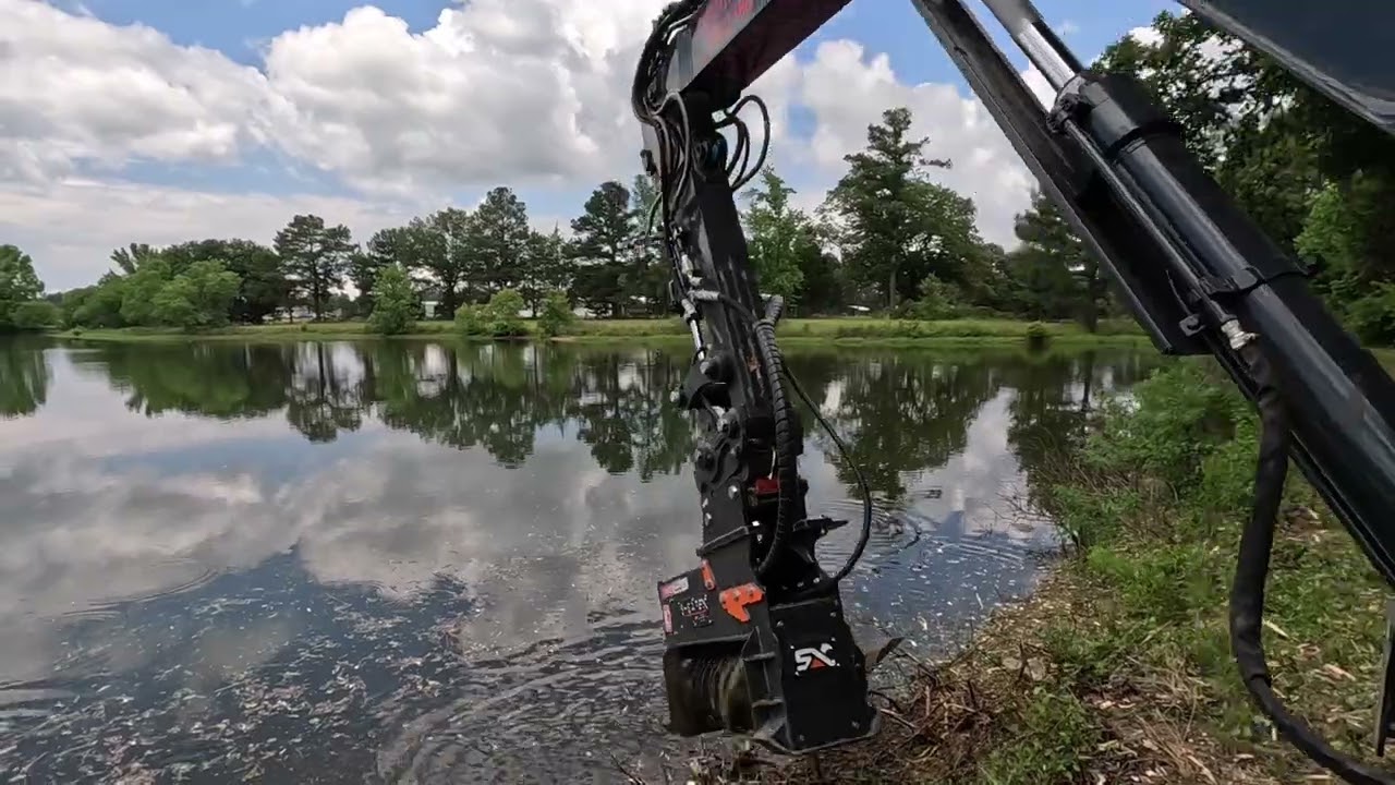 Shearex mulcher clearing off an overgrown pond dam