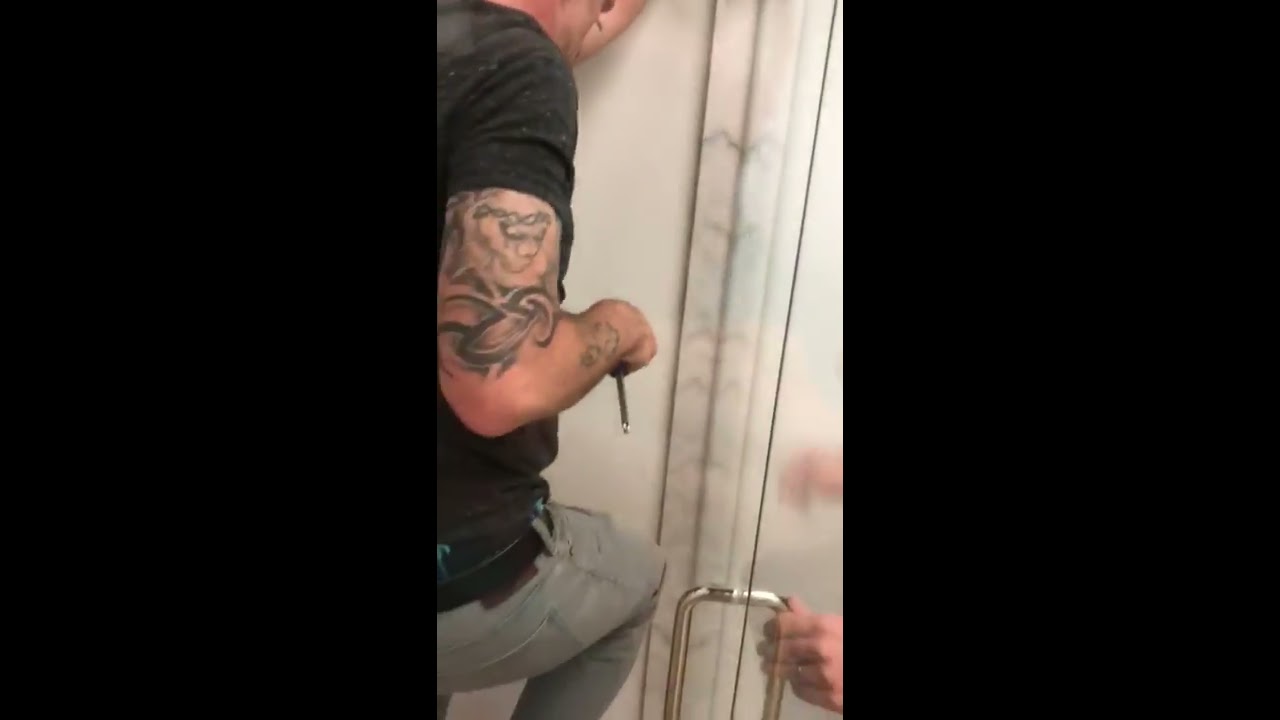 How to adjust sagging frameless door that’s hitting glass panel.