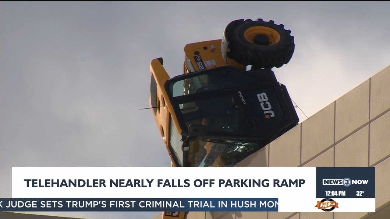Equipment clearing snow tips over edge of parking ramp