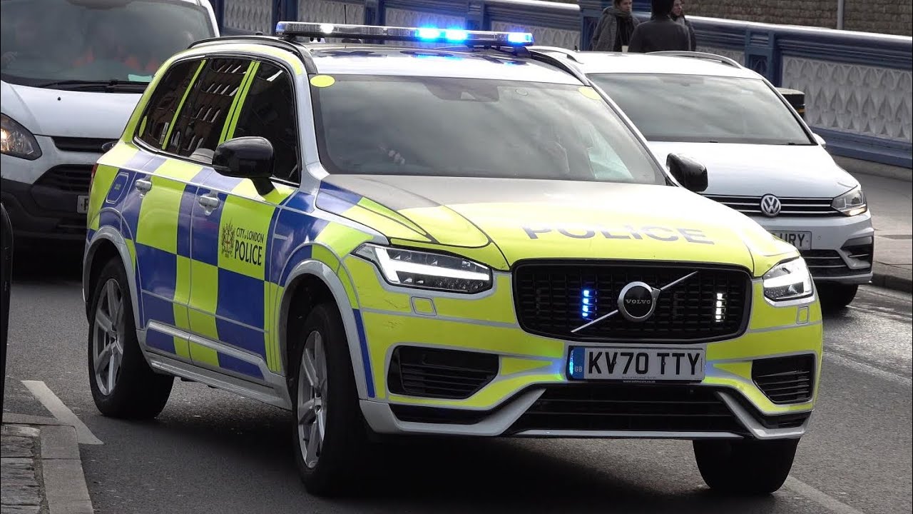 New City of London Police cars responding with siren and lights