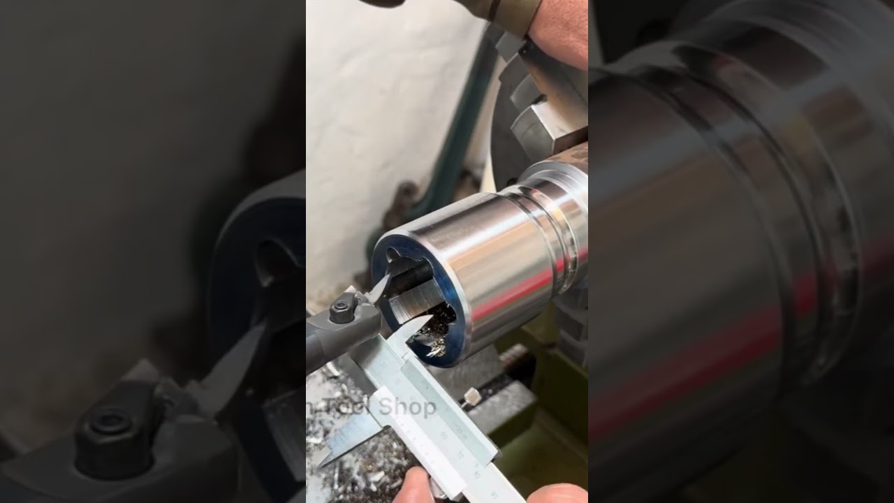 Ekspert mechanik demonstruje na tokarce proces przywracania do życia uszkodzonego klucza pneumatycznego