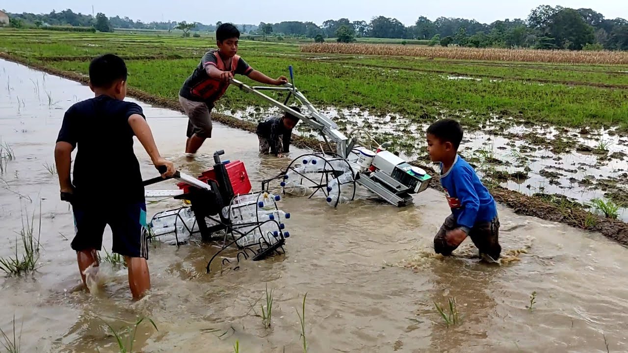 Keseruan dua traktor mini bajak sawah pakai roda botol aqua di sawah yang banyak airnya