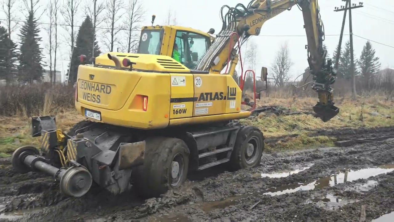 Atlas excavator drives through mud. Экскаватор Атлас едет по грязи.