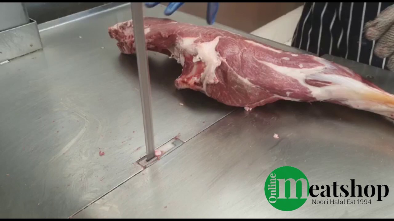 Cutting a mutton leg in half on a bandsaw machine - onlinemeatshop