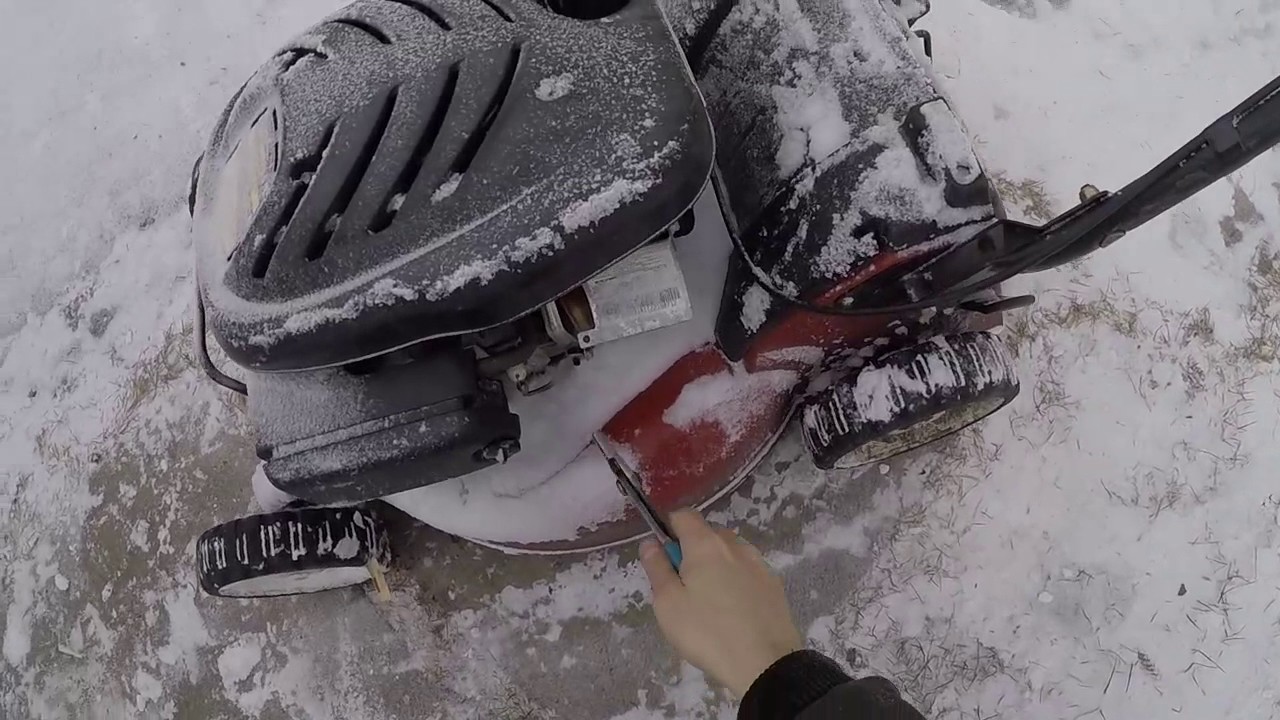 Guy uses lawnmower to clear snow. Mowing snow.