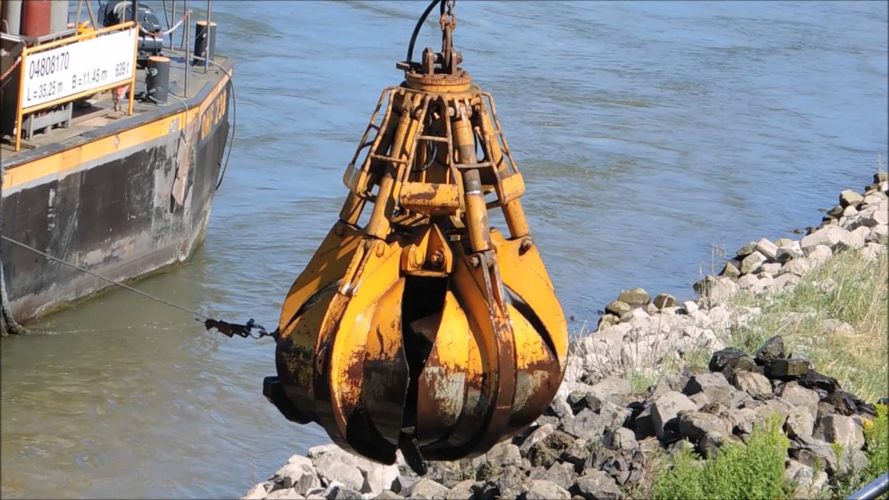 Raupenkran Sennebogen mit Greifer der Rhein bei Düsseldorf