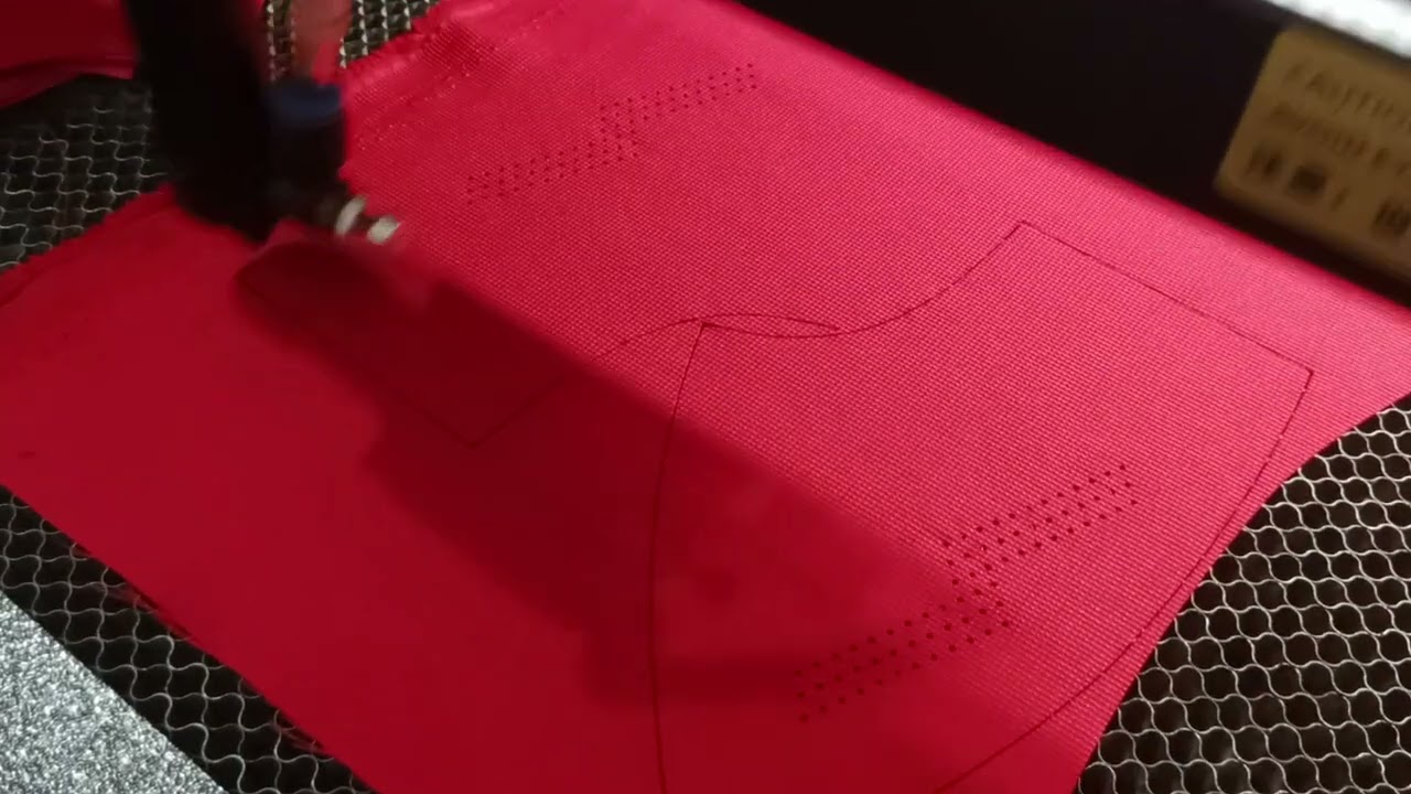 Laser Cutting Process For Golf Cap On Red Material 