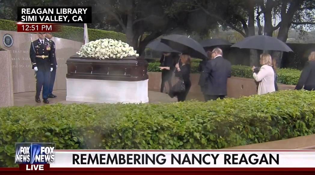 Woman takes a picture with Nancy Reagan's casket