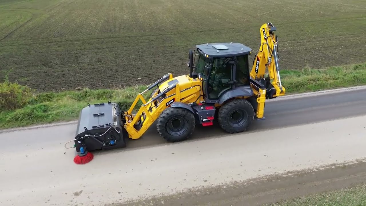 Koparko ładowarka Stroer C 799T praca ze szczotką z kolektorem oraz zraszaczami.