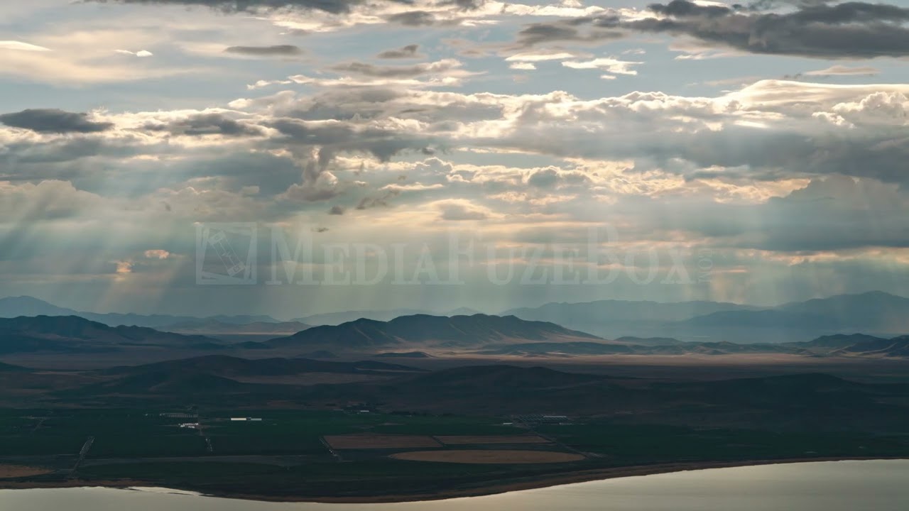 Stock Video - Time lapse of sun rays shining through the clouds moving through the sky