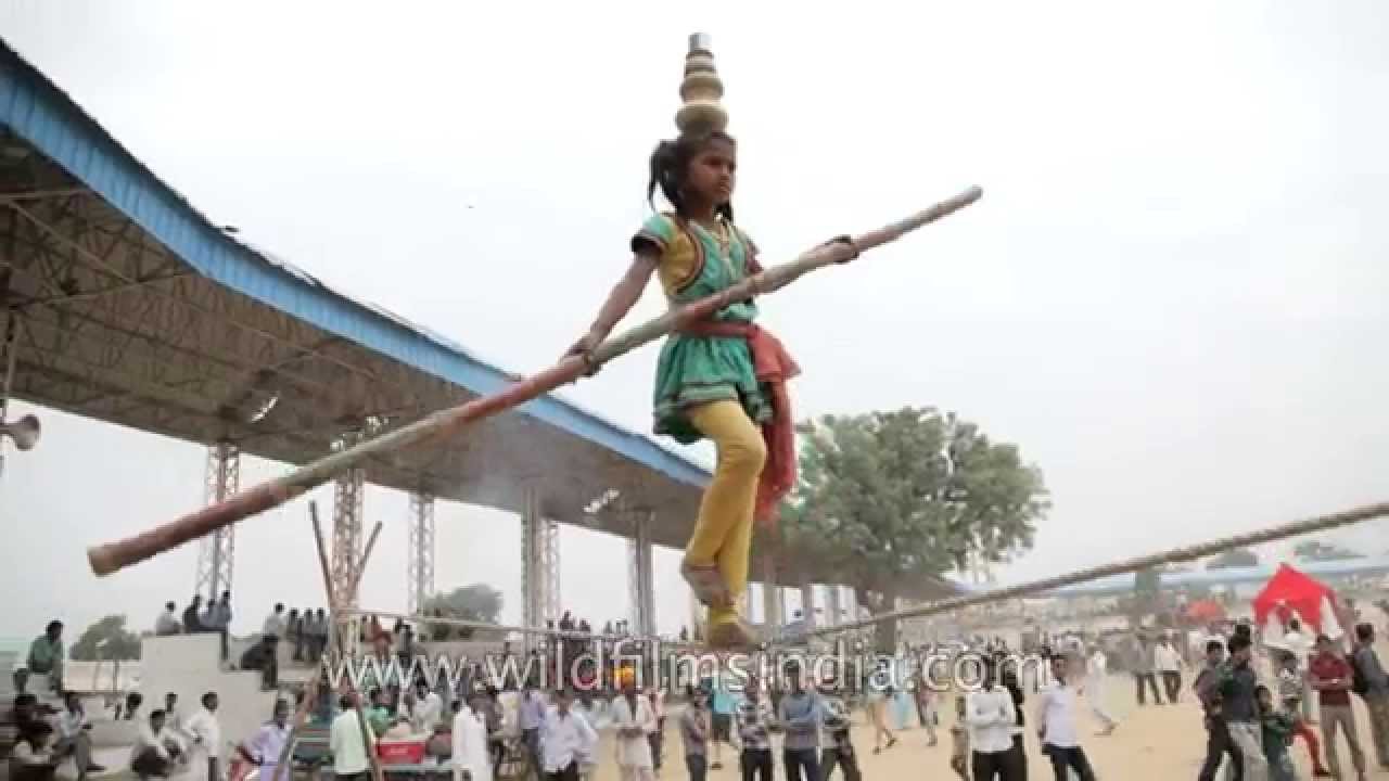 Indian girl does balancing act on a tight rope at Pushkar Mela
