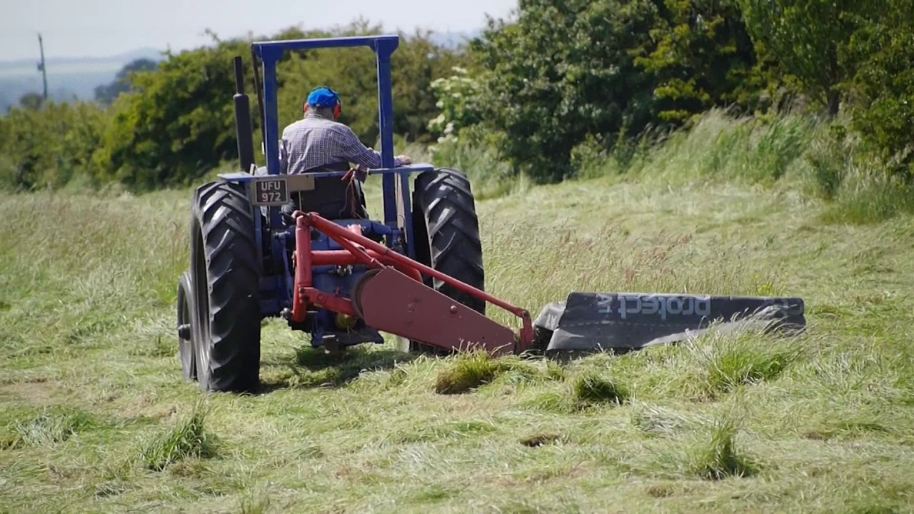 Vintage 1950's Fordson Major tractor with a Kuhn Mower Cutting Hay