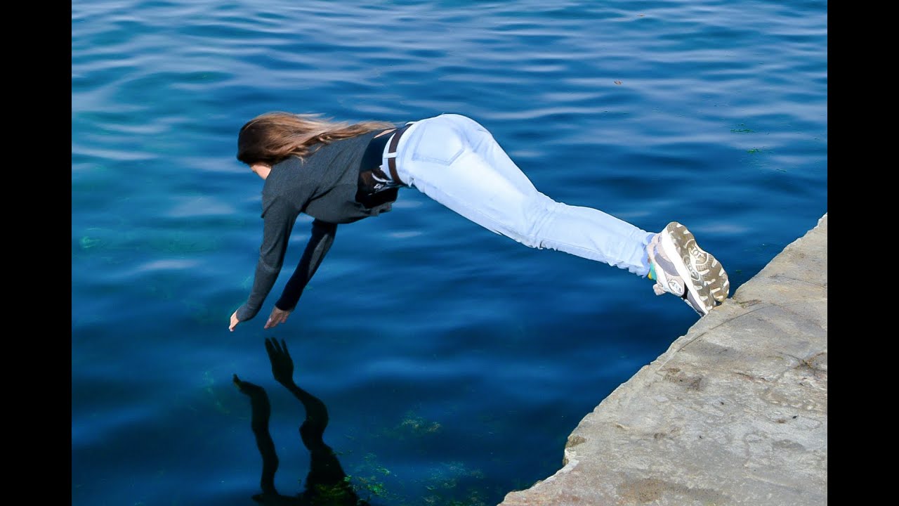 beautiful girl poses in wet clothes on the beach and swims in the sea for wetlook video