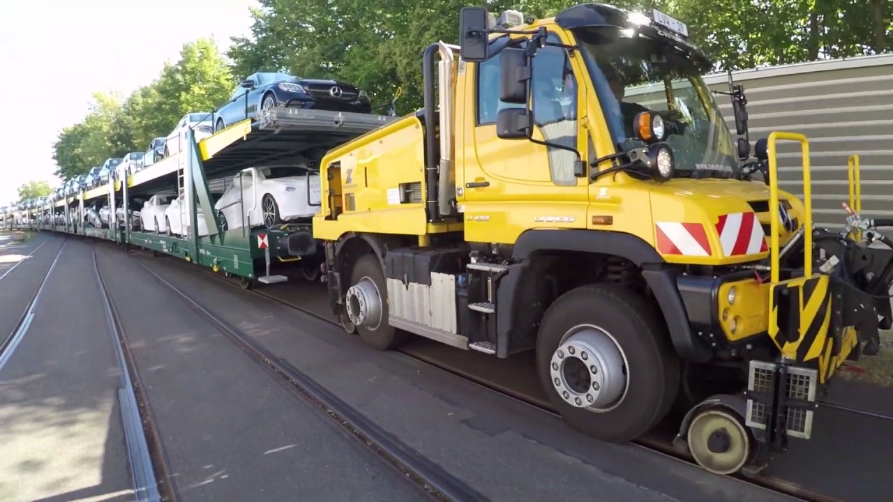 Mercedes-Benz Unimog in Aktion: Zweiwege-Unimog von Zwiehoff bringt Neuwagen auf die Schiene.
