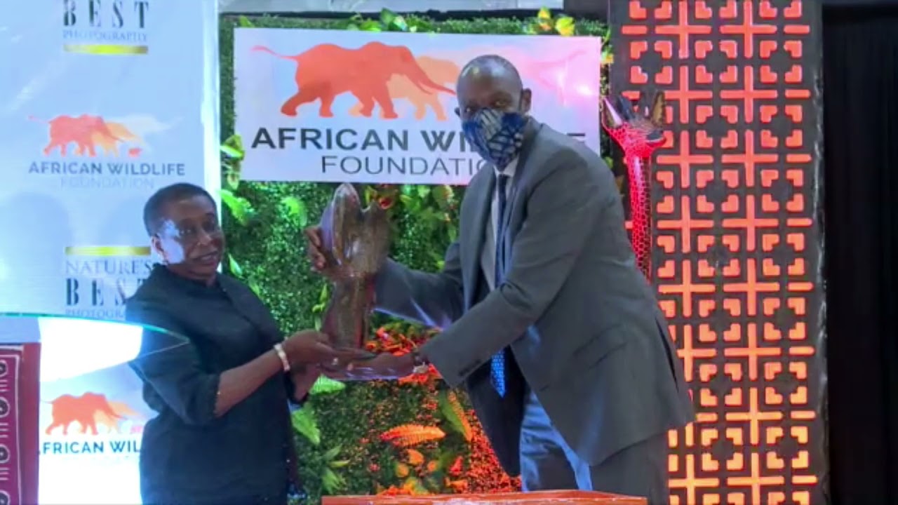 AWF CEO Kaddu Sebunya presenting the Bejamin Mkapa Photography Awards statue to Madam Mkapa