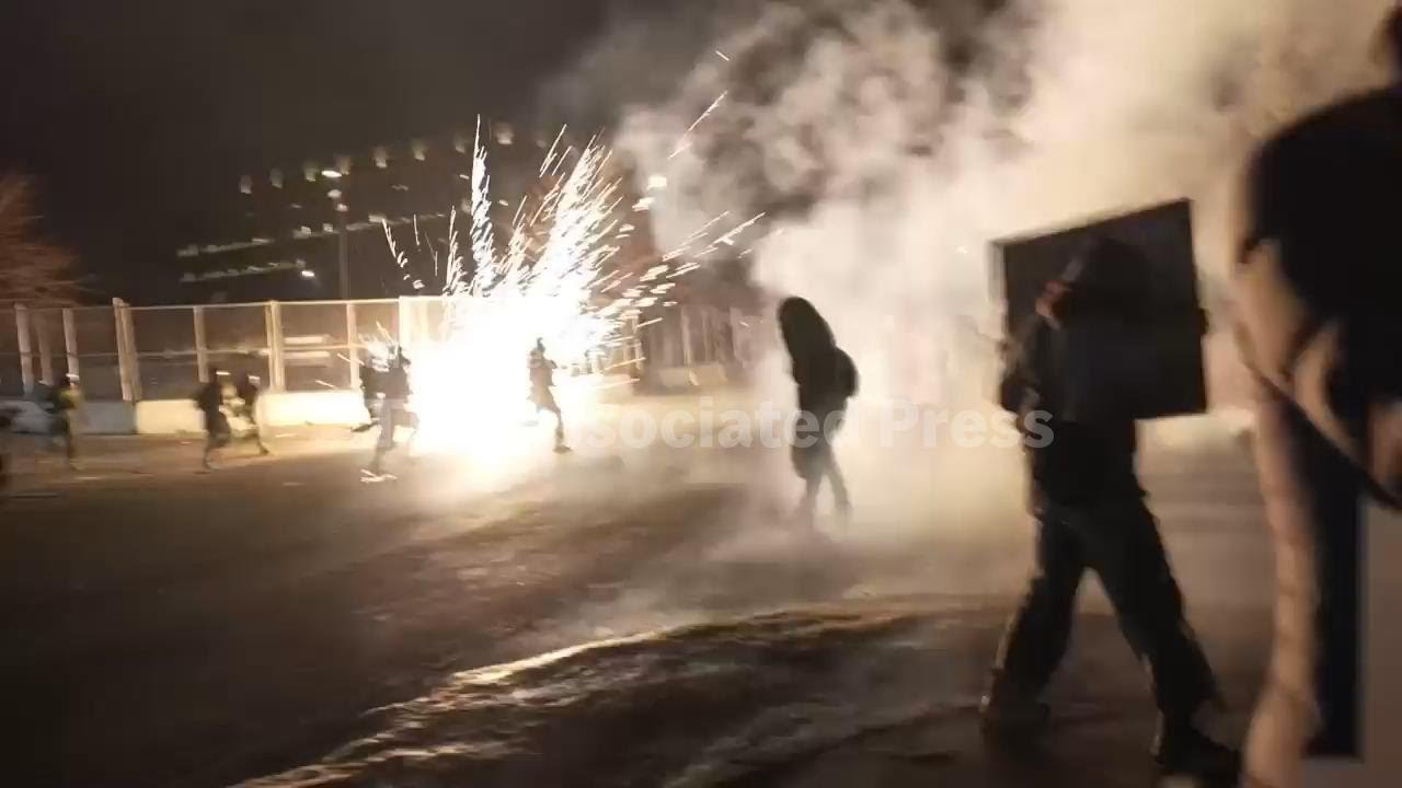 Federal agents toss flashbangs into a crowd of protestors outside a Minneapolis federal building