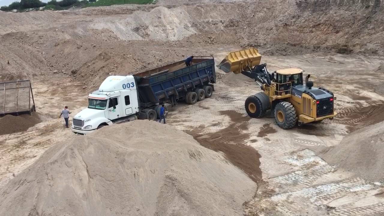 John Deere 824K front wheel loader Loading Sand - cargando arena en góndola