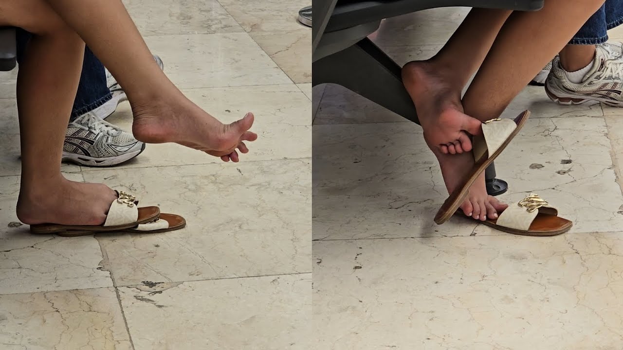 Candid Young Filipina with white toes dangling and dropping her sandals at the airport