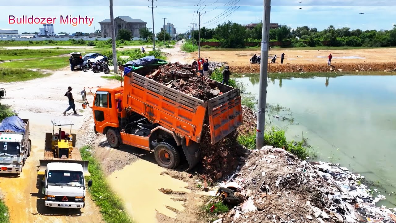 Full Processing Filling Up The Land huge, Bulldozer KOMATSU D31p, Dump Truck Unloading