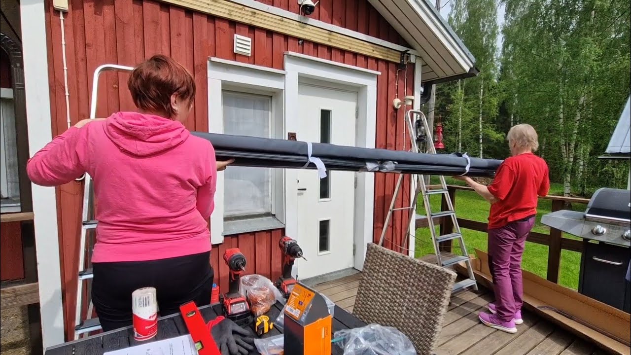 Asennetaan aurinkosuoja mökin terassille