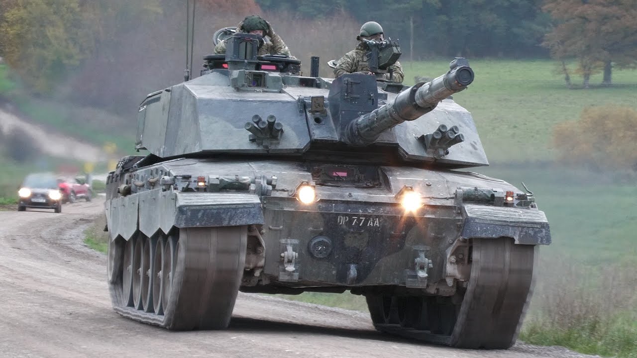 Army tanks and armoury crossing busy road 🪖