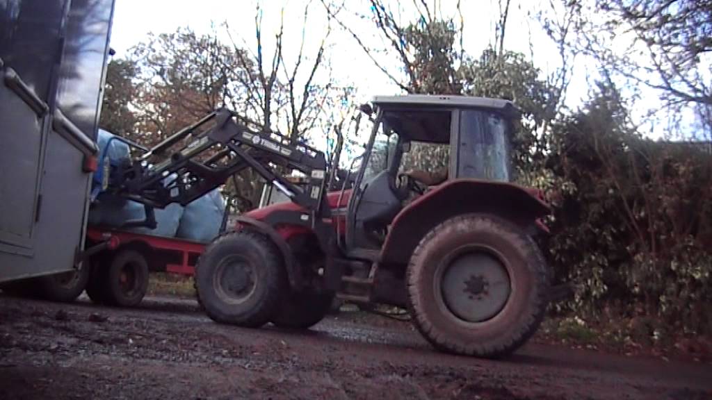 Massey unloading round bales!