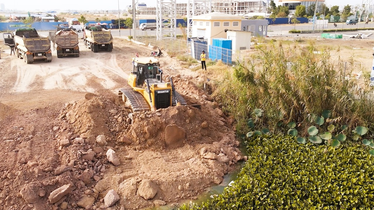 Excellent SHANTUI Bulldozer Push Soils Building Road Across Lake With Team Trucks Dumping