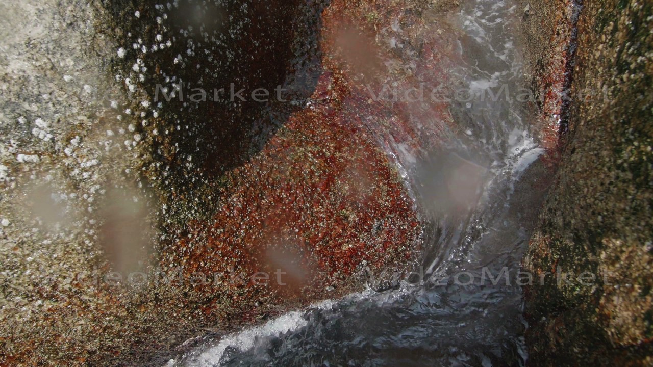 Water flows between stones close-up