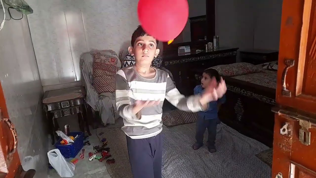 Two babies are playing with ballon
