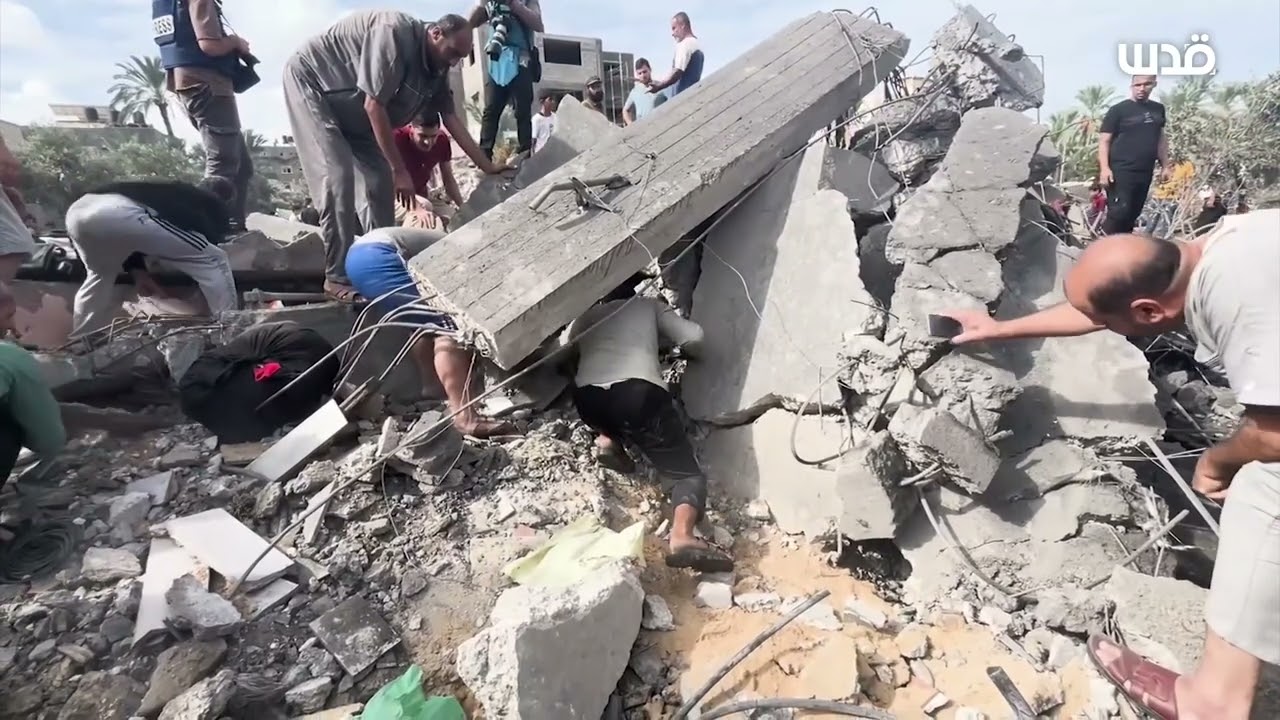 أشخاص يبحثون بين أنقاض المباني المدمرة بحثًا عن الإنقاذ بعد الغارات الجوية على مدينة دير البلح